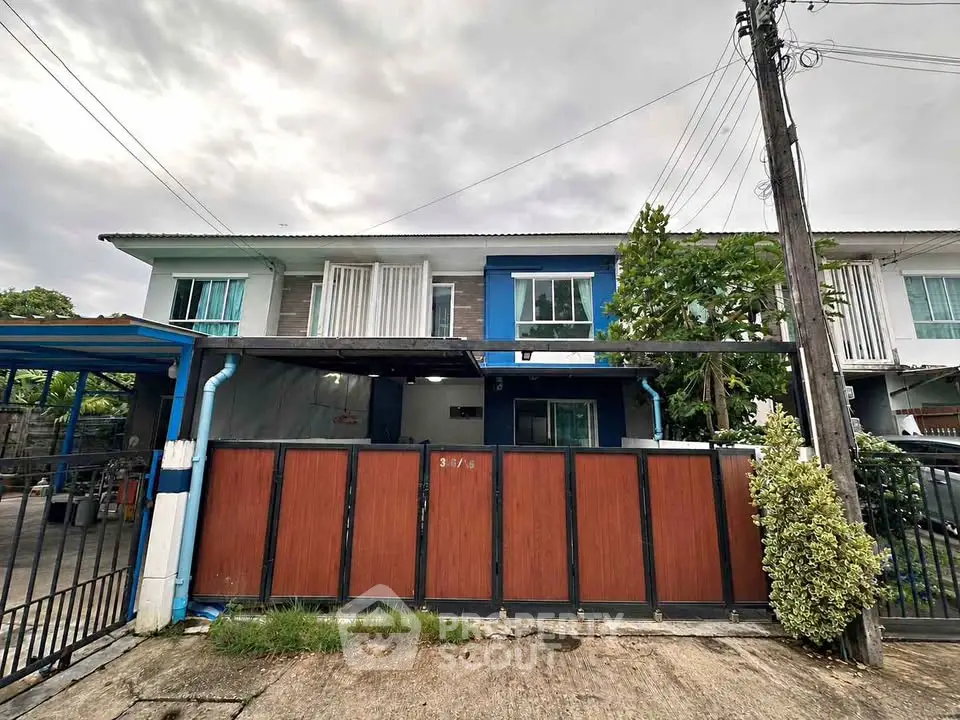 Charming townhouse with gated entrance and vibrant blue accents, perfect for modern living.