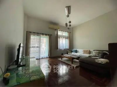 Spacious living room with modern decor and natural light, featuring a cozy sofa and stylish lighting.