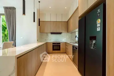 Modern kitchen with sleek wooden cabinetry and marble countertops in a luxury home.