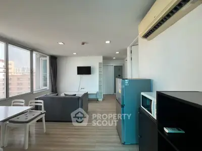 Modern living room with sleek furniture and large windows offering city views