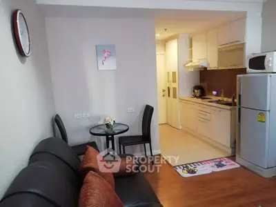 Cozy open-layout living room and kitchen with modern appliances and stylish decor.