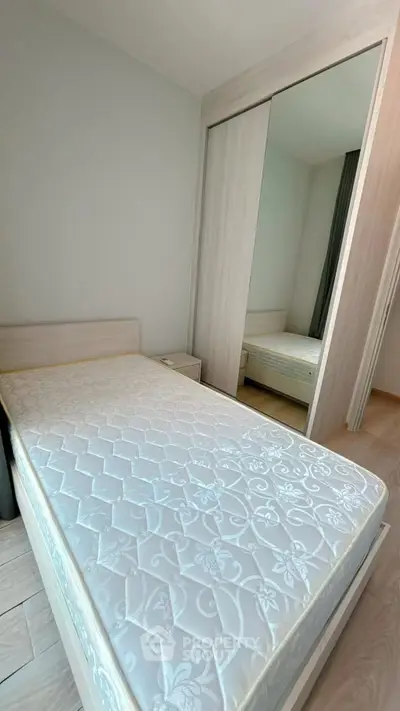 Spacious bedroom with modern design and large mirrored wardrobe