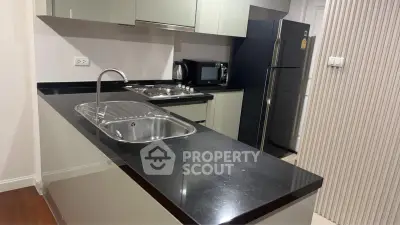 Modern kitchen with sleek black countertops and stainless steel appliances
