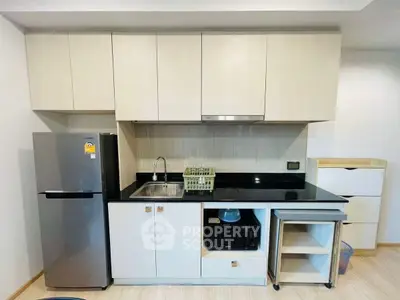 Modern kitchen with sleek cabinetry and appliances in a compact layout