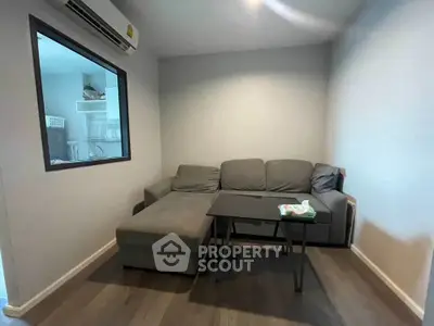 Cozy living room with modern gray sofa and sleek wooden flooring, perfect for relaxation.