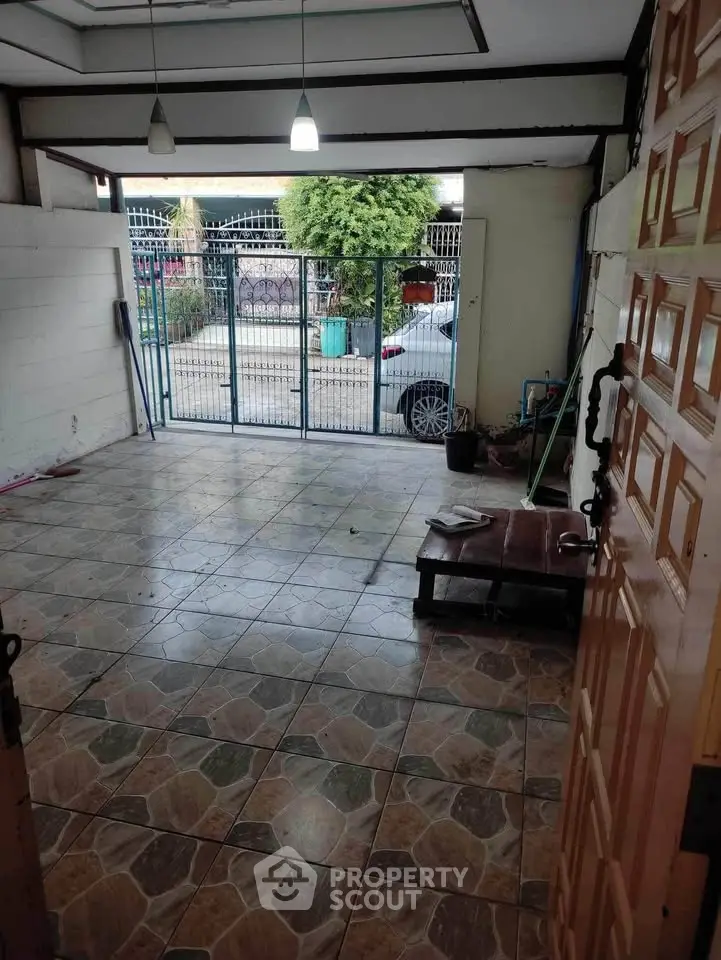 Spacious tiled garage with gated entrance and natural light, ideal for secure parking or storage.