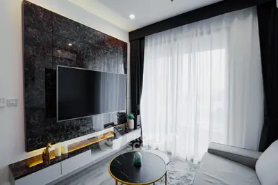 Modern living room with sleek TV setup and elegant curtains
