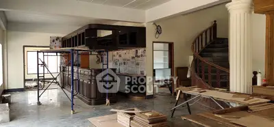 Spacious interior under renovation with elegant spiral staircase and modern bar area.