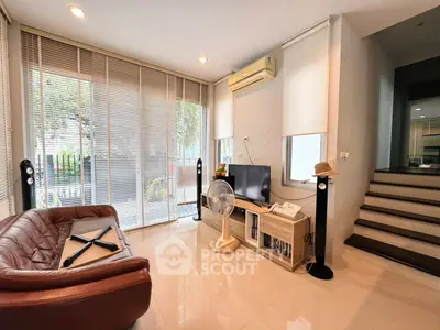 Modern living room with large windows, sleek furniture, and stylish decor in a contemporary home.