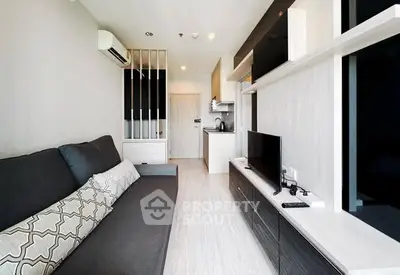 Modern living room with sleek design and open kitchen layout in a stylish apartment.