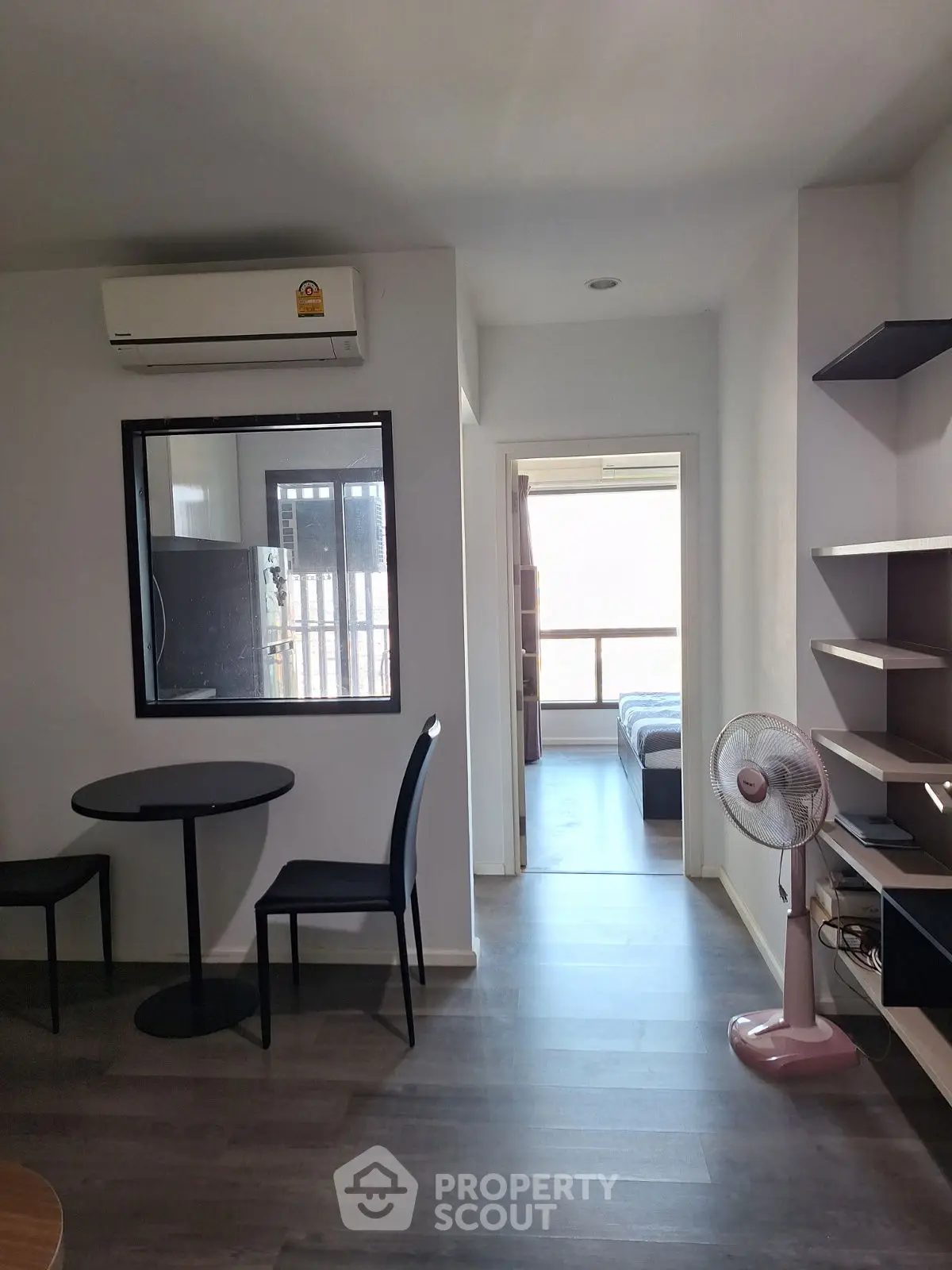 Modern apartment interior with open layout, featuring a cozy living area and a glimpse of the bedroom.