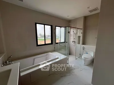Spacious modern bathroom with bathtub and glass shower enclosure