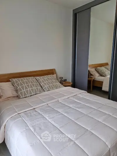 Cozy bedroom with modern decor and large mirror wardrobe