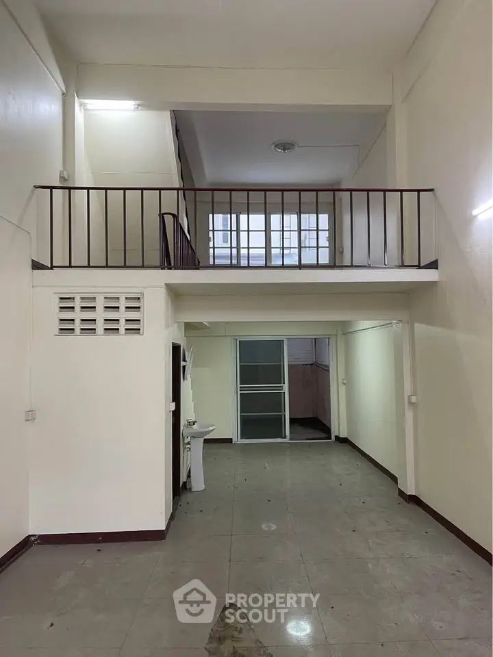 Spacious two-level interior with high ceilings and open layout, ideal for creative renovations.