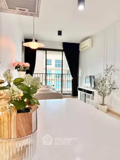 Bright and modern living room with balcony view, stylish decor, and natural light.