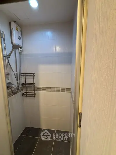 Compact bathroom shower area with modern fixtures and tiled walls