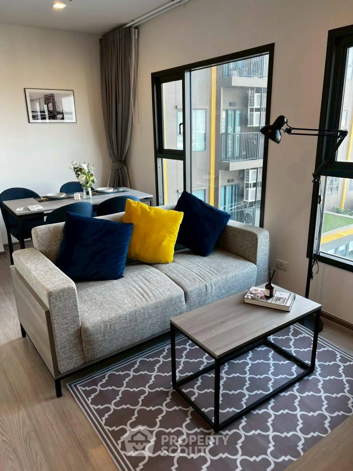 Modern living room with stylish sofa, vibrant cushions, and elegant decor in a bright apartment.