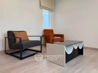 Modern minimalist living room with stylish chairs and unique coffee table.