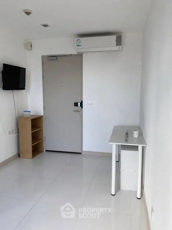Minimalist apartment interior with white walls, small table, and wall-mounted TV, ideal for modern living.