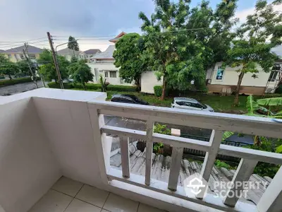 Charming balcony view overlooking a serene neighborhood street with lush greenery.