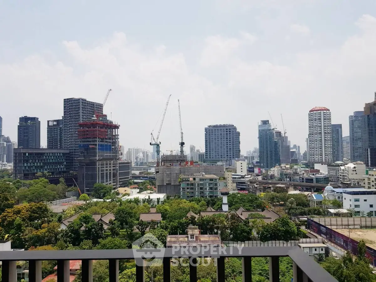 Stunning cityscape view from a high-rise balcony overlooking urban skyline and greenery.
