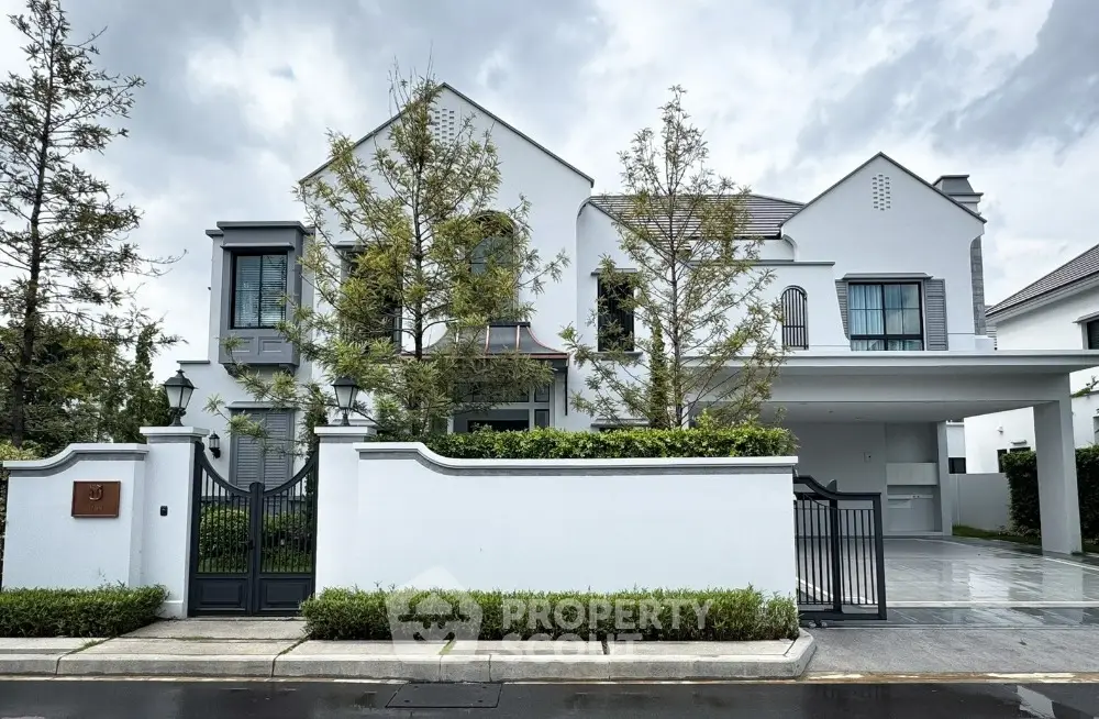 Elegant modern white house with lush landscaping and spacious driveway in upscale neighborhood.