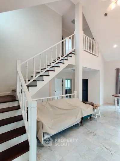Spacious modern living room with elegant staircase and high ceiling