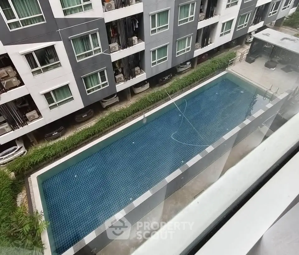 Modern apartment building with a sleek outdoor swimming pool view from above.