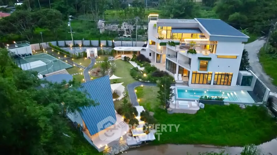 Luxurious modern mansion with pool, tennis court, and lush garden in serene setting.