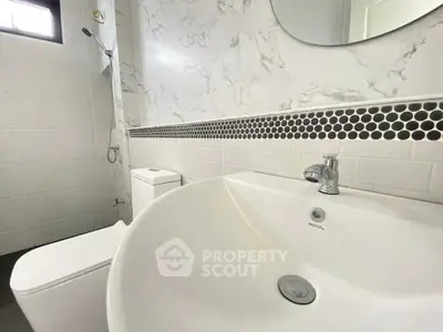 Modern bathroom with elegant sink and stylish tile design.