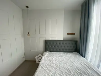 Modern minimalist bedroom with tufted headboard and natural light