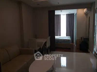 Modern apartment with open living and dining area leading to a cozy bedroom.