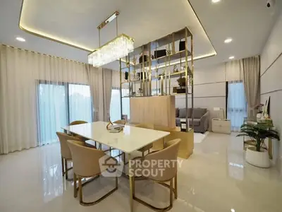 Luxurious open-plan living and dining area with elegant chandelier and modern decor.