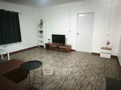 Spacious living room with modern decor and sleek flooring, perfect for relaxation and entertainment.