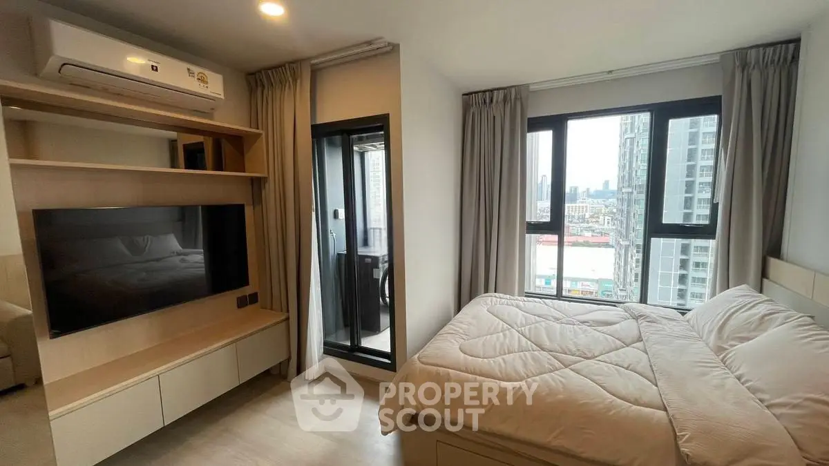 Modern bedroom with city view and balcony access in high-rise apartment