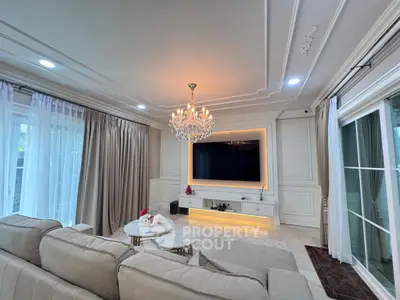 Luxurious living room with elegant chandelier and modern TV setup