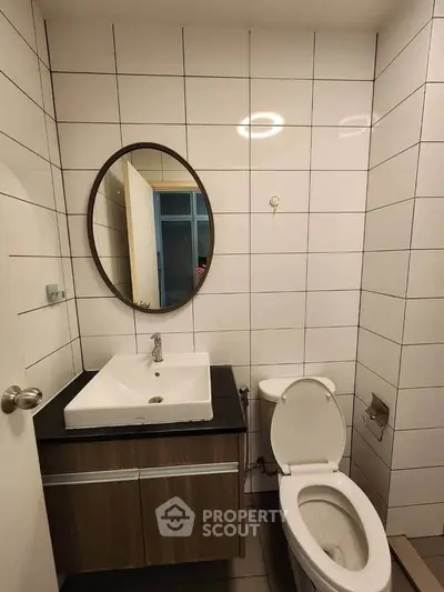 Modern bathroom with sleek fixtures and round mirror in a stylish apartment.
