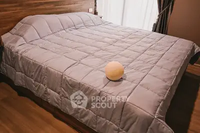 Cozy bedroom with elegant wooden flooring and plush bedding, perfect for relaxation.