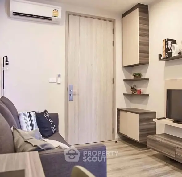 Modern living room with stylish furniture and wall-mounted TV in a cozy apartment.