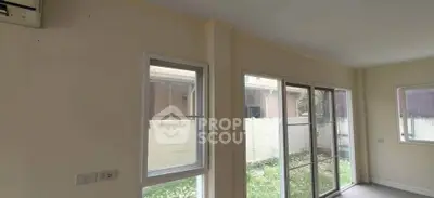 Bright room with large windows and sliding glass doors opening to a garden view, perfect for natural light lovers.