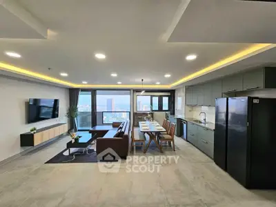 Spacious modern living room with open kitchen and stunning city view