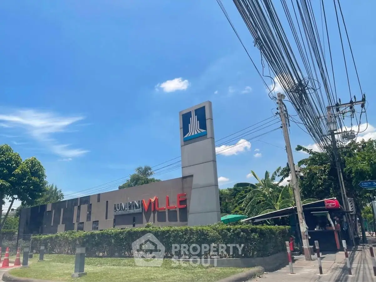 Modern residential building exterior with lush greenery and clear blue sky.