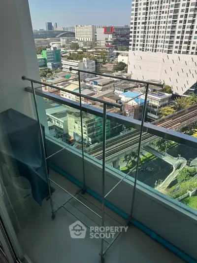 High-rise balcony with city view and drying rack, perfect for urban living.