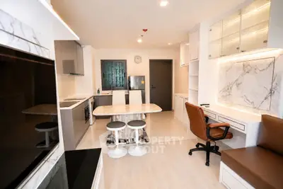 Modern kitchen with marble countertops and stylish seating in a contemporary apartment.