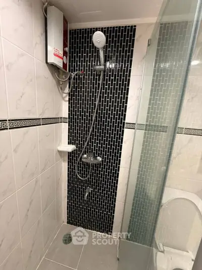 Modern bathroom with stylish black tile shower and glass door