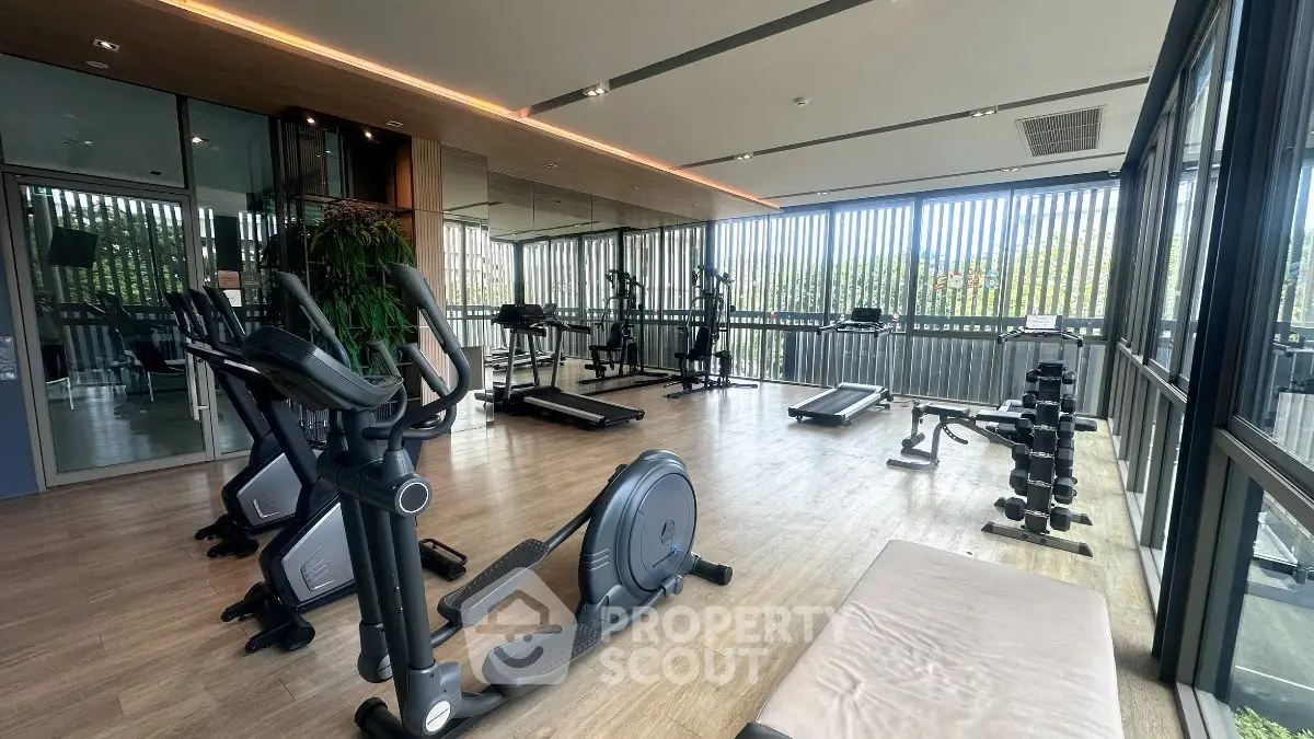 Modern gym with state-of-the-art equipment and large windows offering a scenic view.