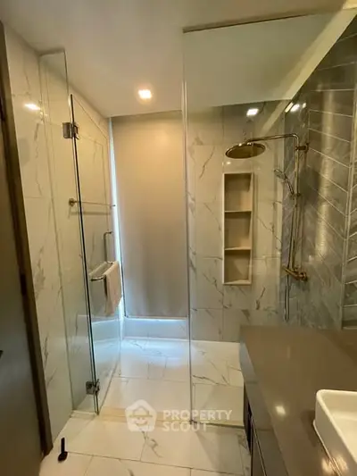 Luxurious modern bathroom with glass shower and elegant marble tiles