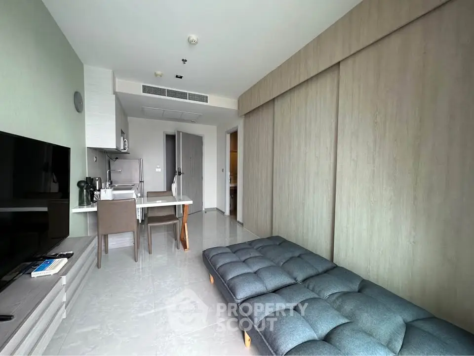 Modern studio apartment with sleek furnishings and open kitchen layout.