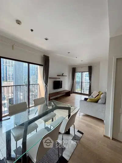 Spacious modern living room with glass dining table and city view, perfect for urban living.