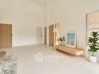Spacious modern living room with minimalist decor and large windows.